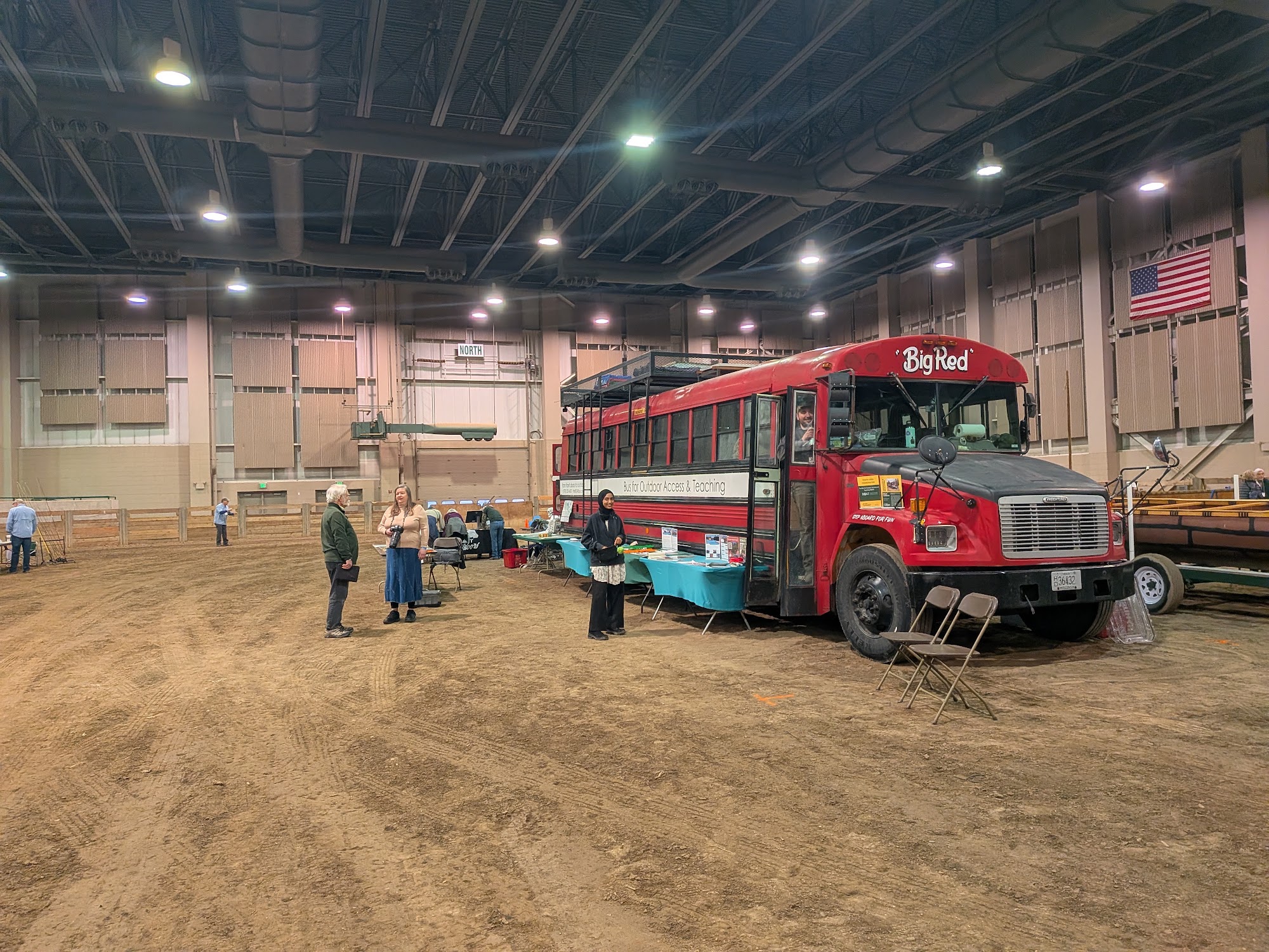 The Get Outside Bus set up with activity tables in an event arena at the Quiet Adventures Symposium