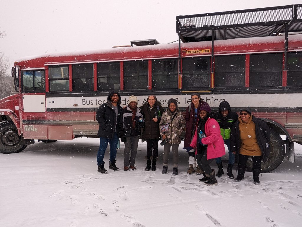 Outdoor Afro participants gathered in front of the Get Outside Bus in the snow